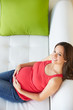 Foto: Overhead View Of Pregnant Woman Relaxing On Sofa Overhead View Of Pregnant Woman Relaxing On Sofa