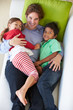 Overhead View Of Father And Children Relaxing On Sofa