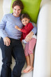Overhead View Of Father And Daughter Relaxing On Sofa