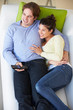 Overhead View Of Couple Watching TV On Sofa