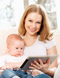 mother and baby with tablet computer on the couch at home