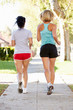 Photo: Rear View Of Two Female Runners On Suburban Street Rear View Of Two Female Runners On Suburban Street