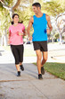 Photo: Couple Running On Suburban Street Couple Running On Suburban Street