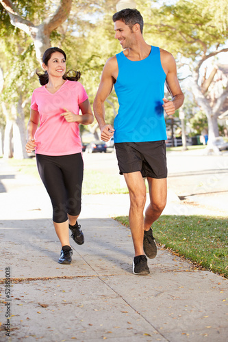 Photo: Couple Running On Suburban Street Couple Running On Suburban Street