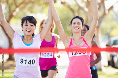 Photo: Two Female Runners Finishing Race Together Two Female Runners Finishing Race Together