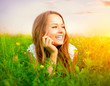 Photo: Beauty Girl in the Meadow lying on Green Grass Beauty Girl in the Meadow lying on Green Grass