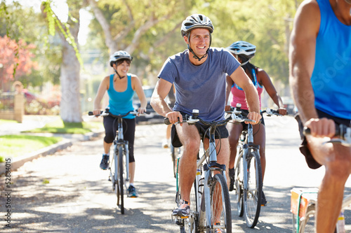 Photo: Group Of Cyclists On Suburban Street Group Of Cyclists On Suburban Street