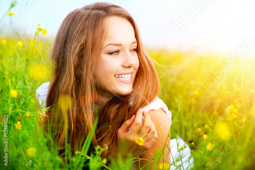 Photo: Beauty Girl in the Meadow lying on Green Grass Beauty Girl in the Meadow lying on Green Grass