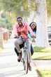 Photo: Couple Cycling Along Suburban Street Together Couple Cycling Along Suburban Street Together