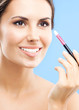 Woman with cosmetics brush, on blue