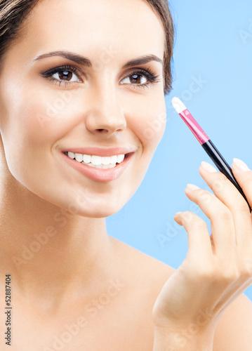 Photo: Woman with cosmetics brush, on blue Woman with cosmetics brush, on blue