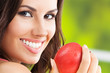 Foto: Young woman with red apple, outdoors Young woman with red apple, outdoors