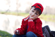 Innocent child sitting on trunk at river