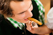 Photo: Man in restaurant or pub eating sausage Man in restaurant or pub eating sausage