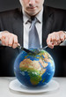 Photo: Greedy businessman cutting planet Earth Greedy businessman cutting planet Earth