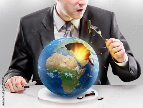 Photo: Greedy businessman eating planet Earth Greedy businessman eating planet Earth
