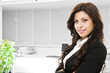 Young smiling business woman posing on office background
