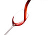 Rotwein wird in ein Weinglas eingegossen