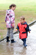 Kinder spielen im Regen