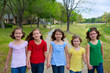 Children group of sisters girls and friends walking in park