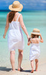 Mother and daughter walking on beach