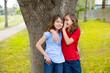 kid friend girls whispering ear playing in a park tree