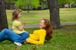 Daughter and mother playing counting lying on lawn