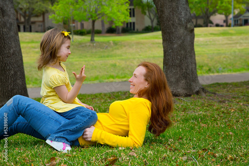 Photo: Daughter and mother playing counting lying on lawn Daughter and mother playing counting lying on lawn