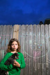 children girl holding puppy dog on backyard wood fence