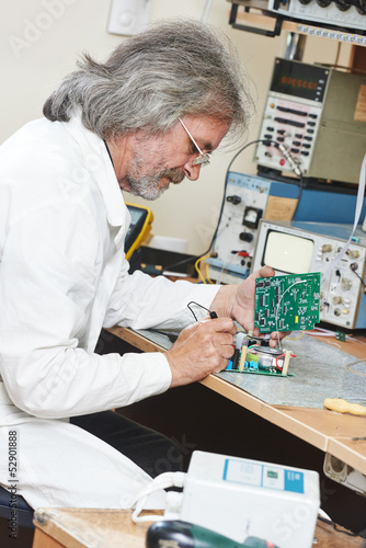 Photo: technician engineer at work with microchip technician engineer at work with microchip