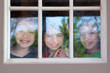 three sister friends looking through the rainy window
