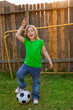 Blond little girl soccer player happy in backyard