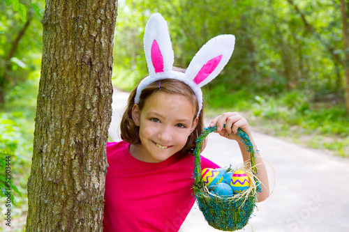 Photo: Easter girl with eggs basket and funny bunny face Easter girl with eggs basket and funny bunny face