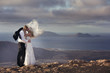 Bride and groom kissing on the volcanic landscape background.