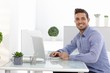 Happy businessman working on laptop