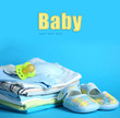 Pile of baby clothes on blue background