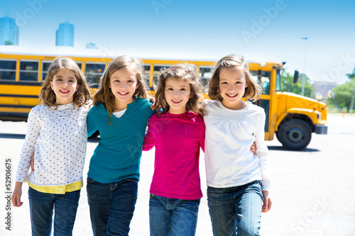Photo: school girls friends in a row walking from school bus school girls friends in a row walking from school bus