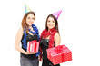 Photo: Two female friends standing close together and holding gifts at Two female friends standing close together and holding gifts at