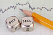 Dices cubes with the words SELL BUY, pencil and financial chart