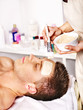Clay facial mask in beauty spa.