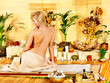 Photo: Woman getting massage in bamboo spa. Woman getting massage in bamboo spa.