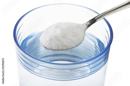 Photo: Spoon of baking soda over glass of water Spoon of baking soda over glass of water