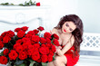 Beautiful brunette woman with red roses bouquet flowers at inter