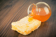 Honeycomb and honey jar on table background