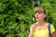 Foto: girl blowing on a dandelion. girl blowing on a dandelion.