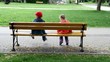 two children in the park sitting on the bench