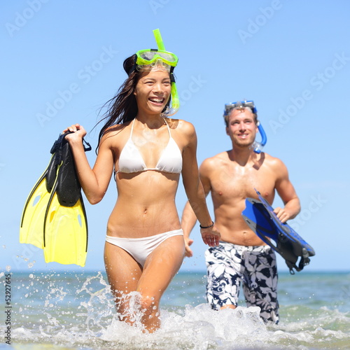 Photo: Beach couple having fun on vacation travel snorkel Beach couple having fun on vacation travel snorkel