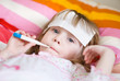 girl lying in bed with a thermometer