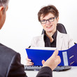 Business woman with folder speaks to man in a suit