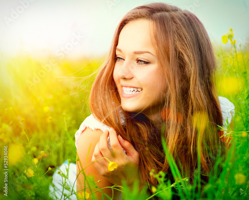 Photo: Beauty Girl in the Meadow lying on Green Grass Beauty Girl in the Meadow lying on Green Grass